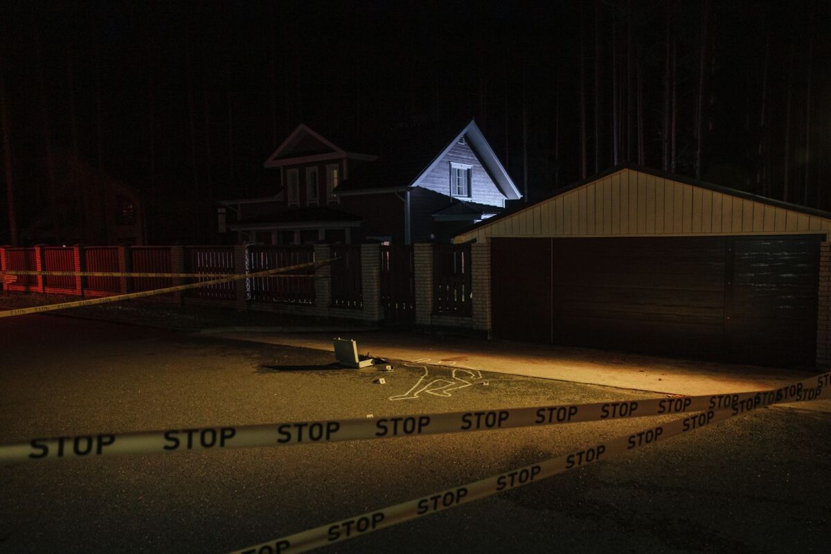 Scène de crime nocturne balisée avec des repères de police au sol